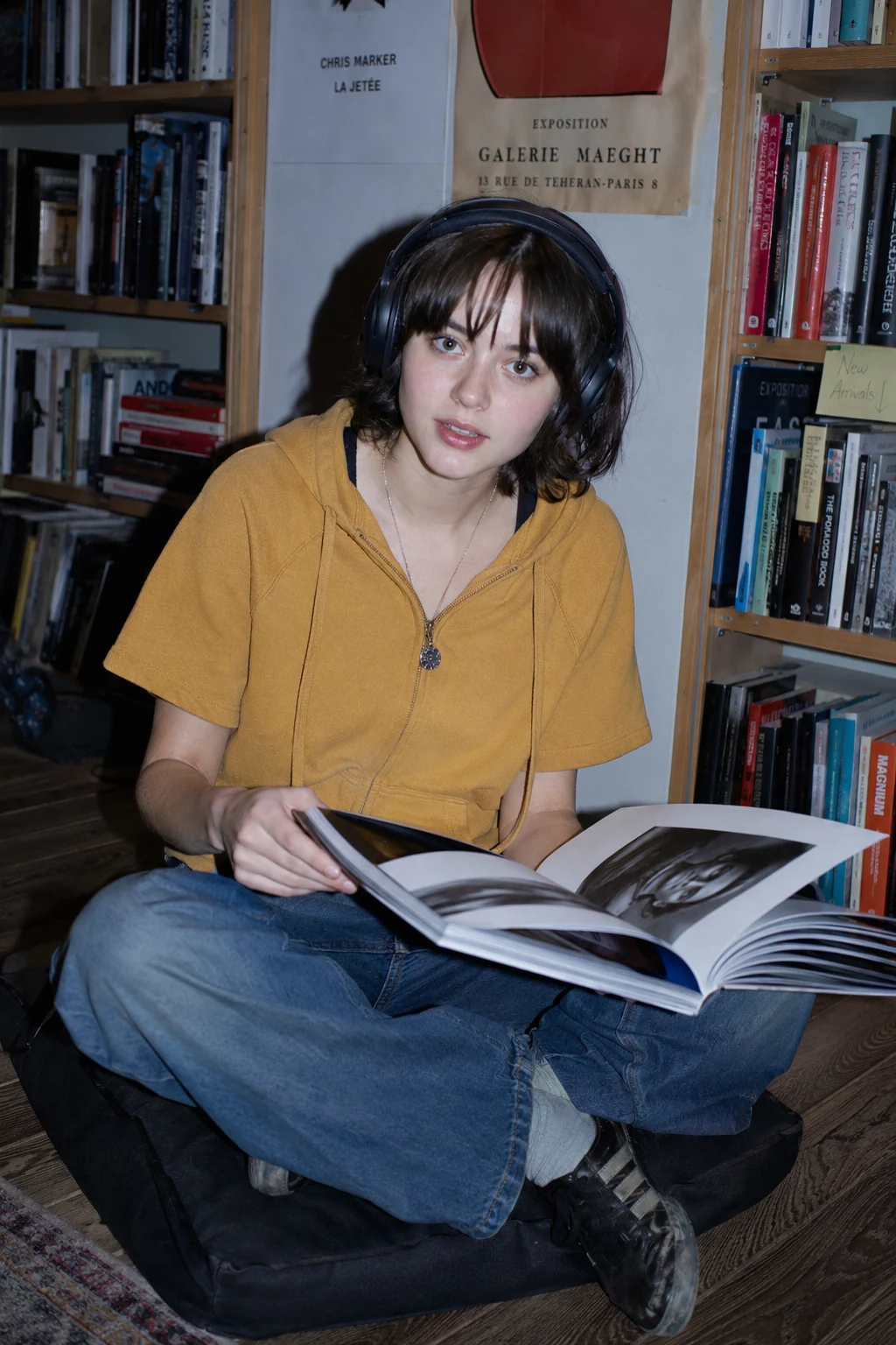 Direct on-camera flash candid of girl with headphones in late-night bookstore